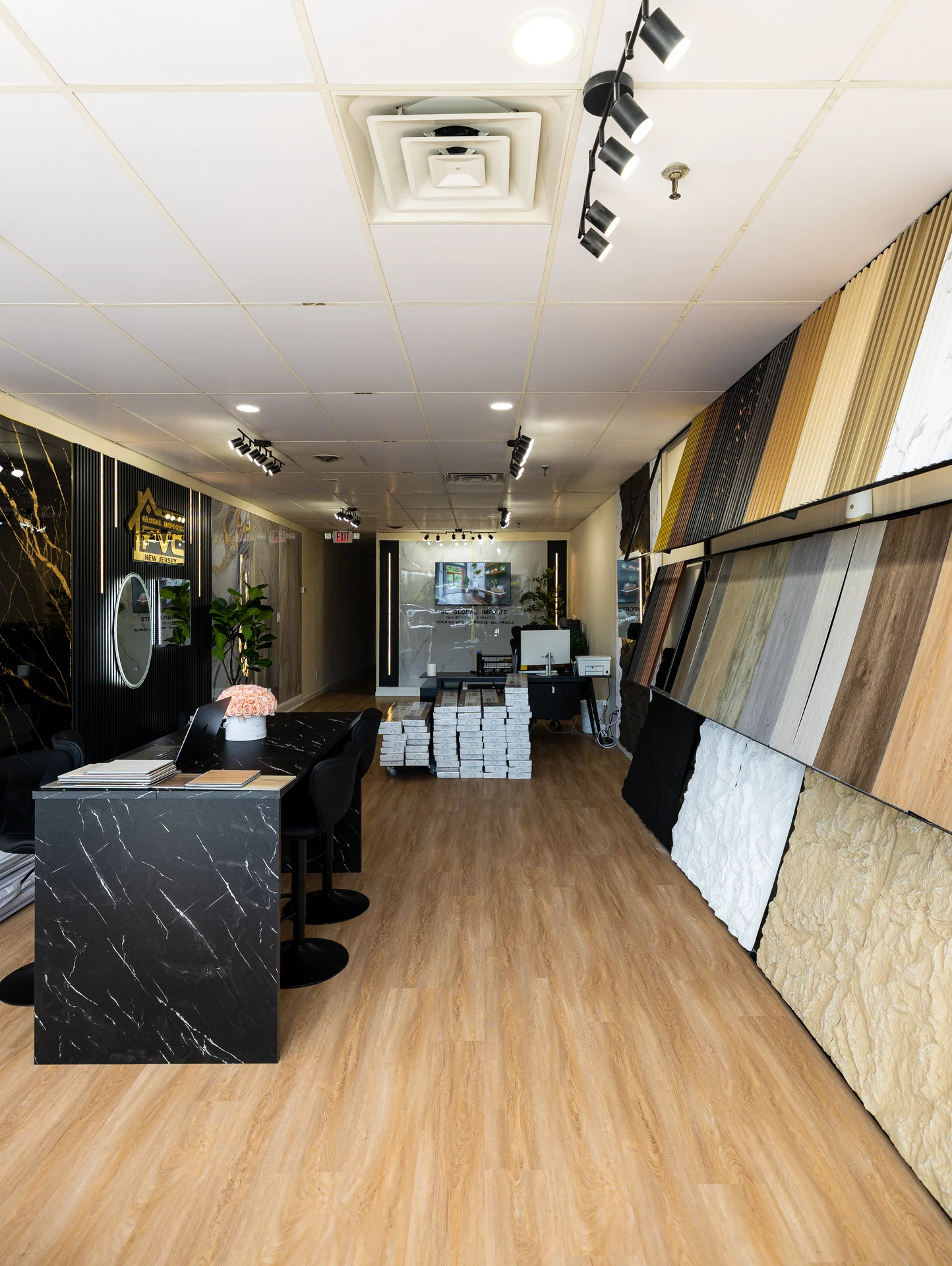 Showroom with various wall panels, spc flooring samples, and led lighting in a modern space. by PVC Global Imports USA LLC in